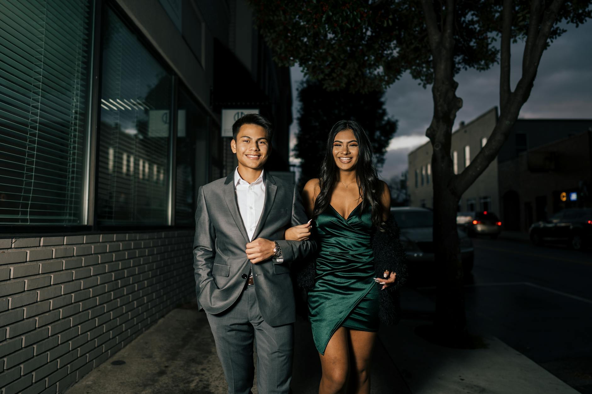 man in gray suit standing beside woman in green dress